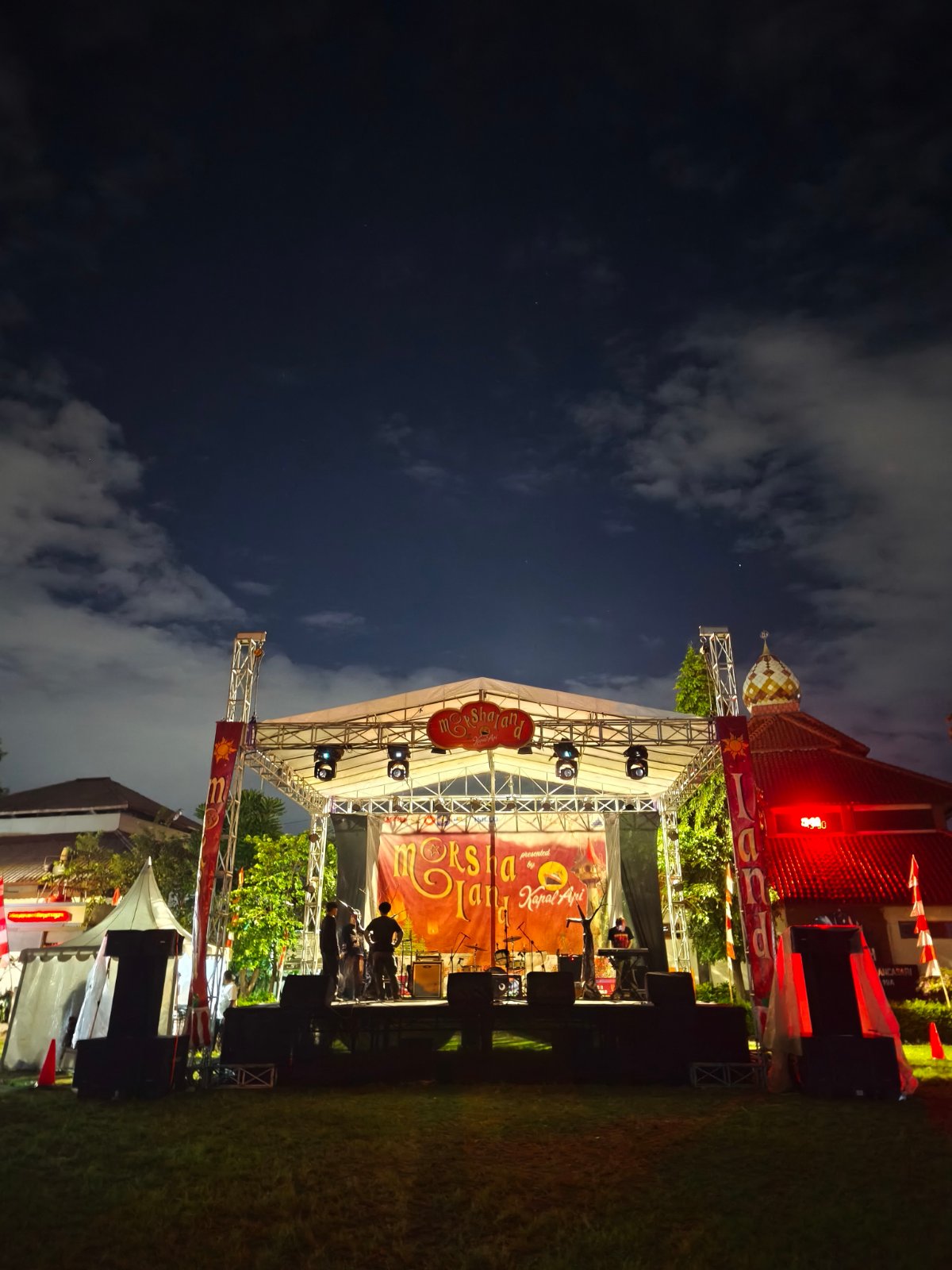 Panggung rigging dengan lighting dan sound system untuk festival musik malam hari di Bandung