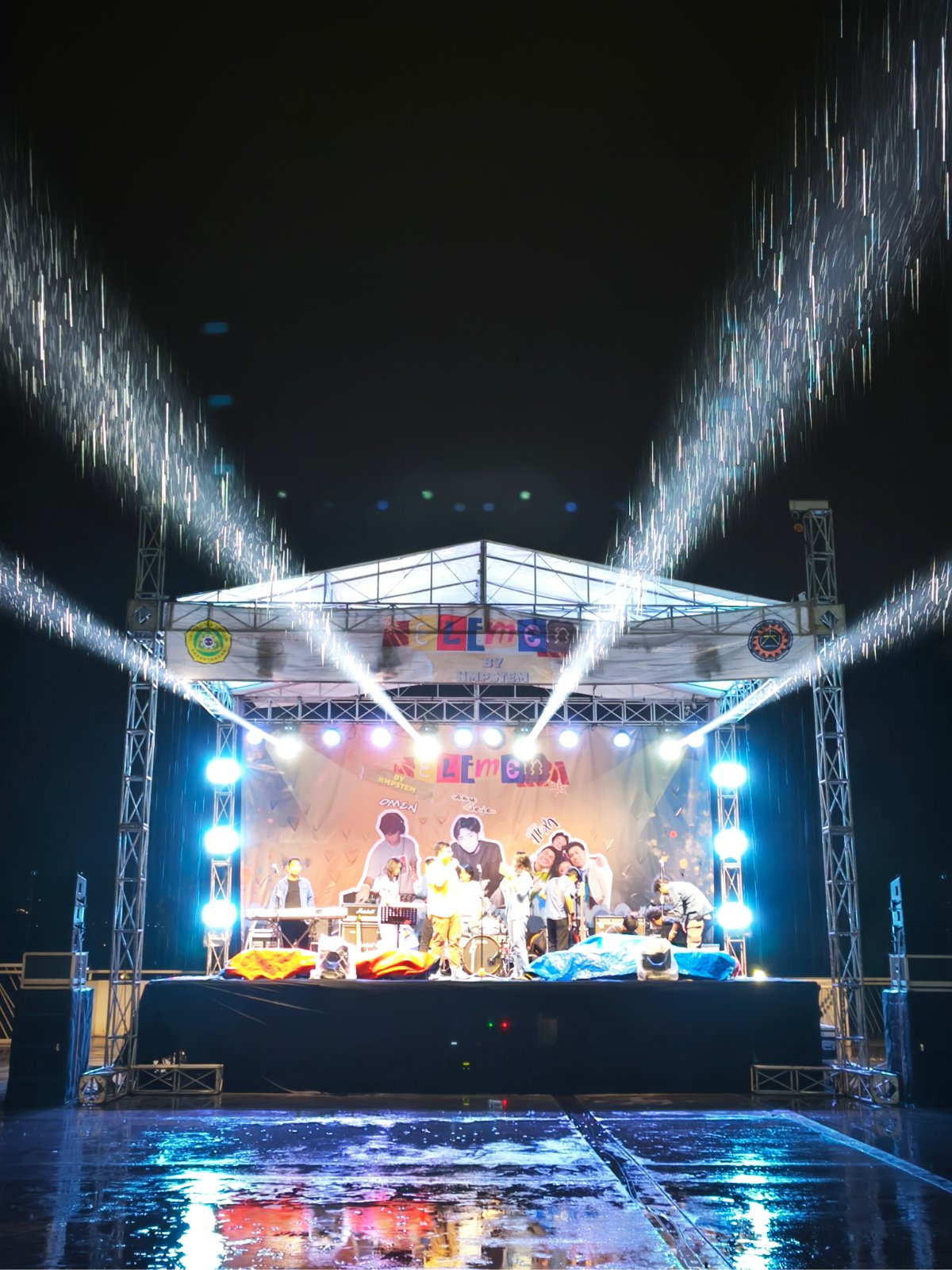 Panggung rigging beratap dengan lighting beam untuk konser kampus saat hujan
